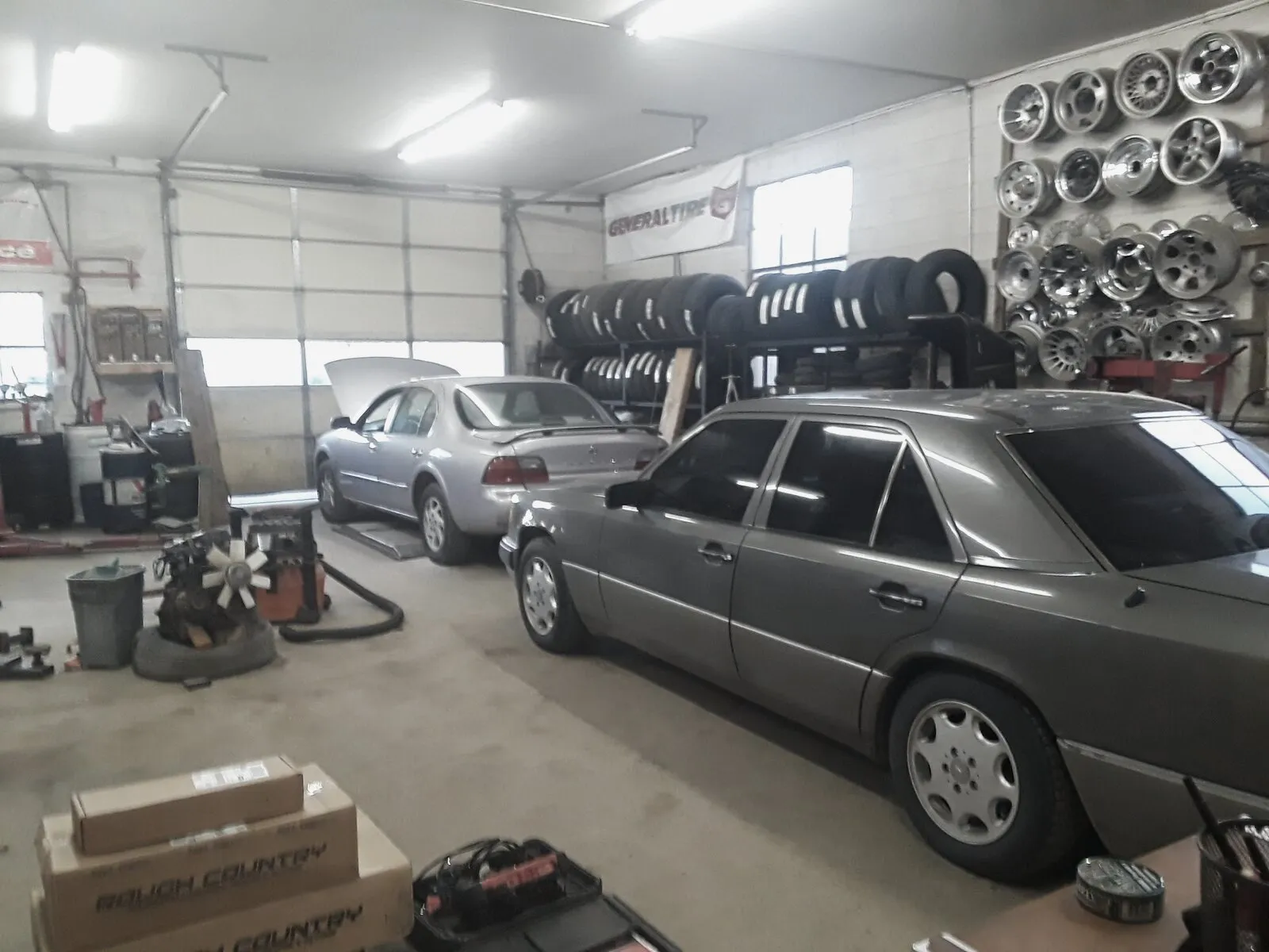 Inside the Star Tire service bay, cars on lifts and a wall of wheels
